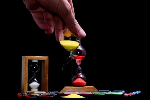 Deadline Concept Broken Hourglass with Yellow Sand on Black Background