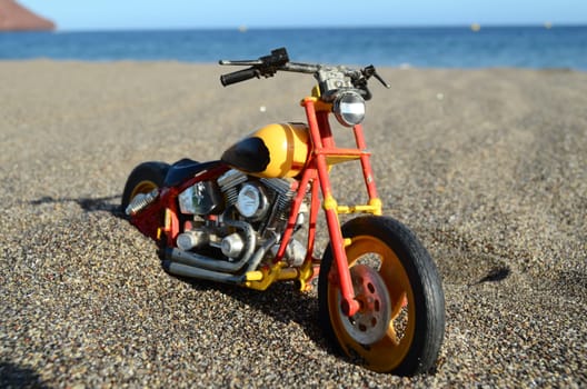 Transportation Concept Toy Motorcycle on the Sand Beach