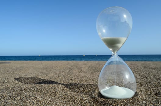 One Hourglass on the Sand Beach Near the Ocean Time Concept
