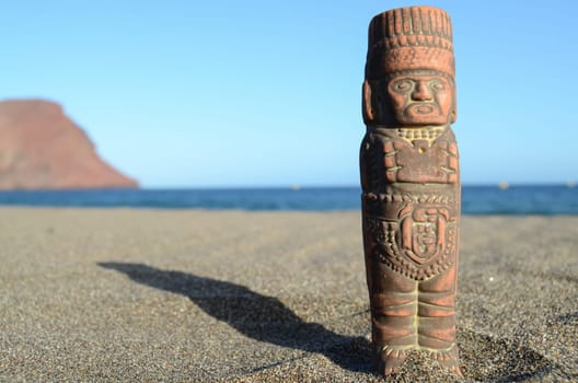 Ancient Maya Statue on the Sand Beach near the Ocean