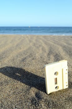 Ancient Retro Musicassette on the Sand near the Water