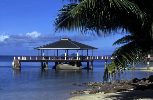 A hotel beach with a gazebo at sunset on praslin island in the Seychelles in the Indian Ocean.