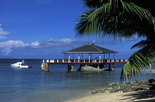A hotel beach with a gazebo at sunset on praslin island in the Seychelles in the Indian Ocean.
