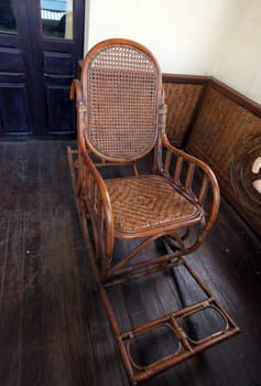 Ein Schaukelstuhl in einem kollonialen Haus und Hotel in der Stadt Savannahet in zentral Laos an der Grenze zu Thailand in Suedostasien.