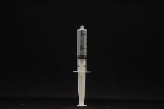 Black and White Syringe on a Dark Background