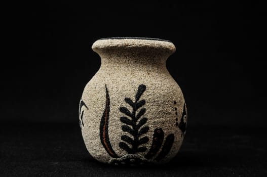 Colorful designed clay vase over a Black background