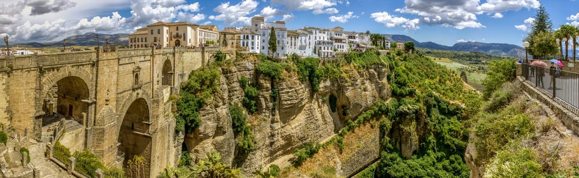 Ronda Panoramic view over Puente Nuevo ("New Bridge"") The newest and largest of three bridges that span the 120-metre (390 ft)-deep chasm that carries the Guadalevín River and divides the city of Ronda, in southern Spain. Built between 1759-1793, the architect was José Martin de Aldehuela."