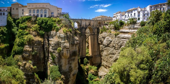 Ronda Panoramic view over Puente Nuevo ("New Bridge"") The newest and largest of three bridges that span the 120-metre (390 ft)-deep chasm that carries the Guadalevín River and divides the city of Ronda, in southern Spain. Built between 1759-1793, the architect was José Martin de Aldehuela."