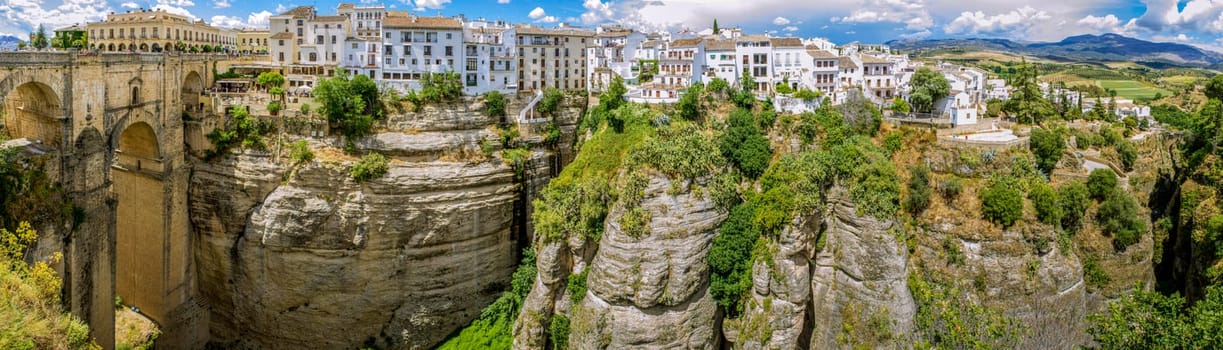 Ronda Panoramic view over Puente Nuevo ("New Bridge"") The newest and largest of three bridges that span the 120-metre (390 ft)-deep chasm that carries the Guadalevín River and divides the city of Ronda, in southern Spain. Built between 1759-1793, the architect was José Martin de Aldehuela."