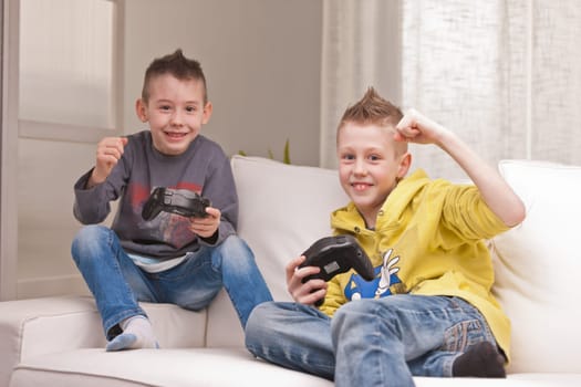 two little boys having lots of fun with video games