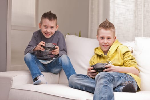 two little boys having lots of fun with video games