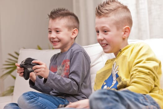 two little boys having lots of fun with video games