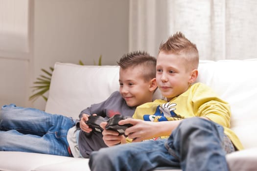 two little boys having lots of fun with video games