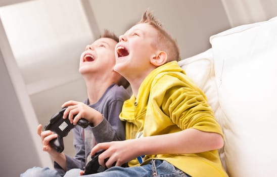 two little boys having lots of fun with video games