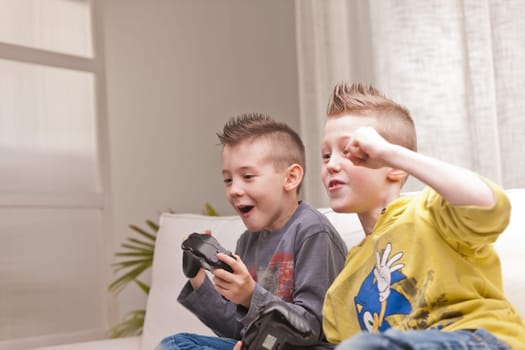 two little boys having lots of fun with video games