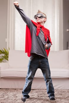 a little kid playing as a red cloak serious superhero