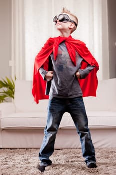 a little kid playing as a red cloak serious superhero