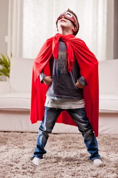 a little kid playing as a red cloak serious superhero