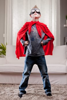 a little kid playing as a red cloak serious superhero