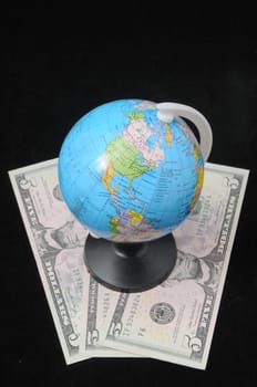 Round Globe and Money on a Dark Backgruond
