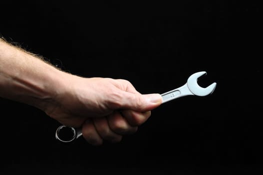 One Key Bolts and a Hand on a Black Background