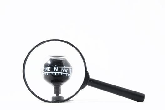 Orientation Concept Magnify Glass and Compass on a White Background