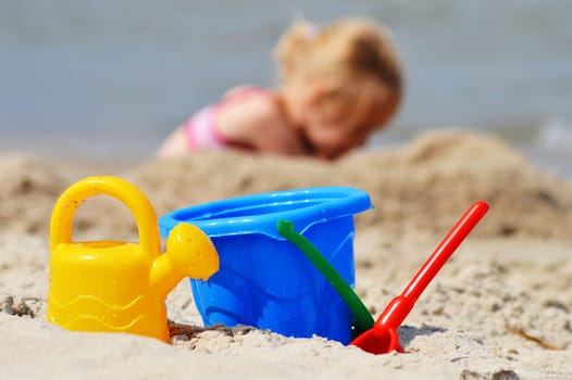 Little girl playing on the sand beach.