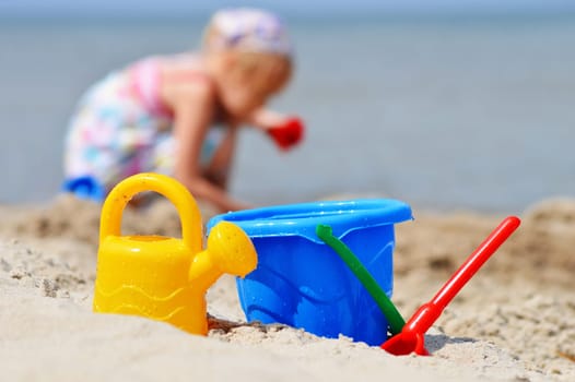 Little girl playing on the sand beach.