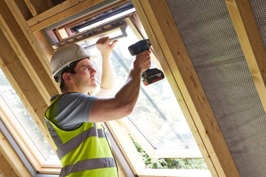 Construction Worker Using Drill To Install Window