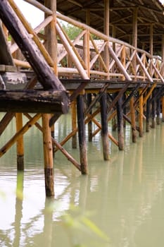 The base of wooden bridge over lake in garden
