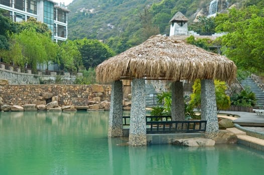 The pavilion with thatch roof beside swimming pool