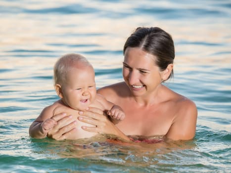 Baby and mother having fun time in the sea
