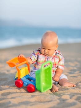 Cute baby is playing toy car