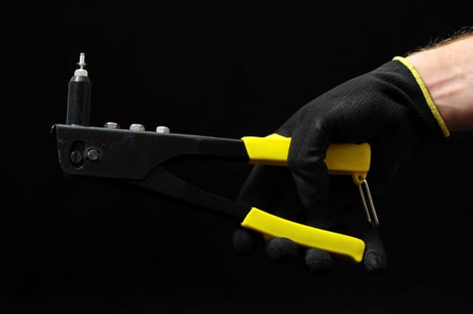 Rivets Pliers and a Hand on a Black Background