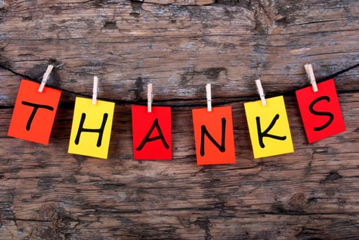 The Word Thanks on Colorful Tags on a Line on Wood