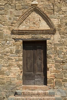 Medieval wooden door. Entrance to the church. (Montalcino, Italy)
