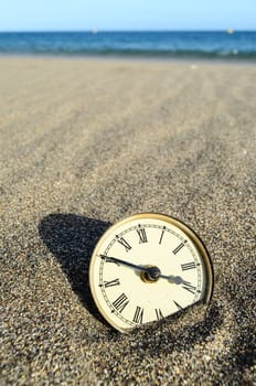 Classic Analog Clock In The Sand On The Beach Near The Ocean