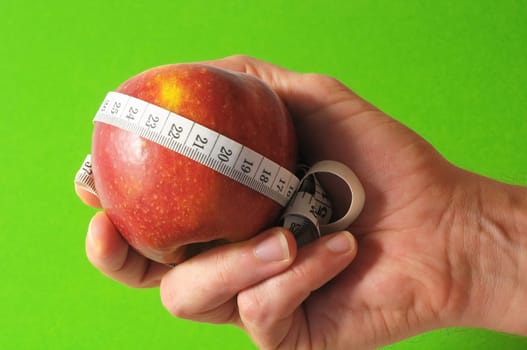 Diet Apple and Meter on the Hand on a Colored Background
