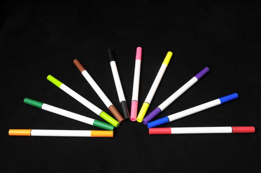Some Colored Ink Markers on a Black Background