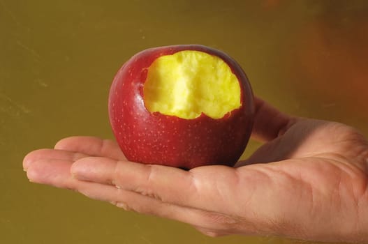 Bitten Red Apple on Hand on a Colred Background