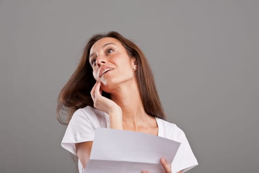 a beautiful brunette fascinated by something loving she read on a white letter or document