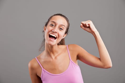 exulting girl because of something succesful or winning fact with an arm and a hand upright