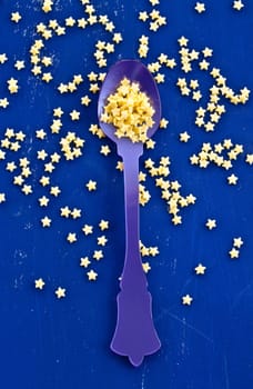 Yellow sugar stars in vintage loeffel on blue