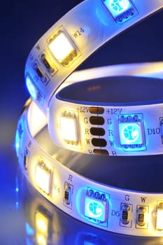 Macrodetail of an RGBW LED strip with warm white LEDs in colored light