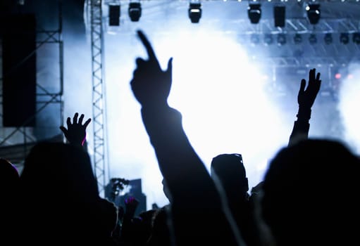 Cheering crowd in front of bright colorful stage lights