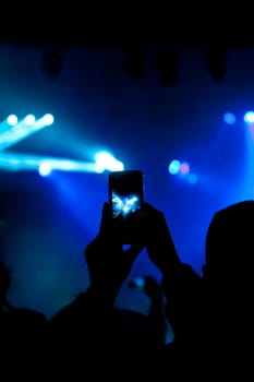 Cheering crowd in front of bright colorful stage lights
