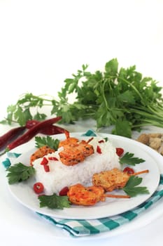 Meat skewer with rice and pepperoni on a white plate