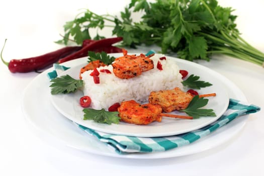 Meat skewer with rice and pepperoni on a white plate