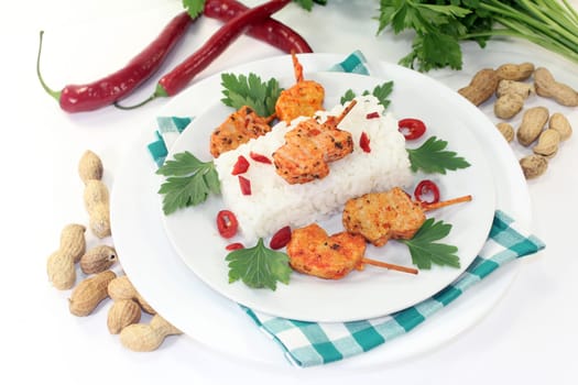 Meat skewer with rice and pepperoni on a white plate