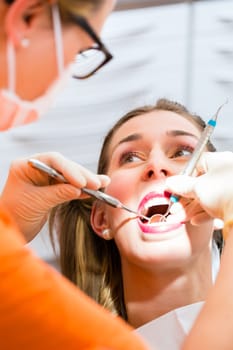 Patient having deep dental tooth cleaning at dentist